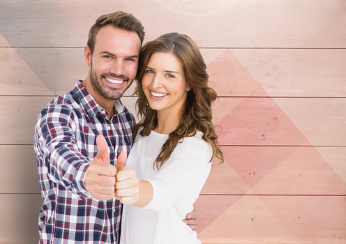 Romantic couple showing thumbs up against wooden background