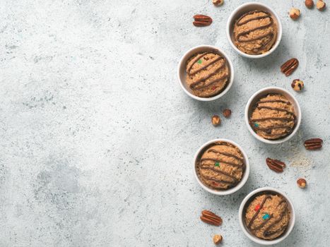 Safe-to-eat raw monster cookie dough in small portion bowl on gray cement background. Ideas and recipes for kids and toddlers meal. Top view or flat-lay. Copy space for text.