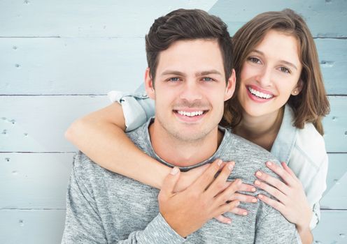 Portrait of romantic couple embracing each other against wooden background