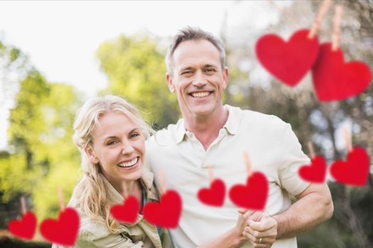 Composite image of romantic couple enjoying together with red hearts hanging on line