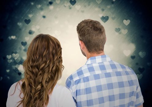 Rearview of romantic couple against digitally generated heart background