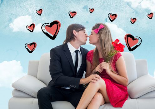 Composite image of romantic couple kissing on sofa against hearts and sky in background