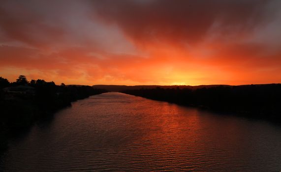 Blazxing red sky sunset over Nepean River Penrith Australia