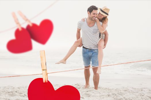 Composite image of romantic couple enjoying on the beach with red hearts hanging on line