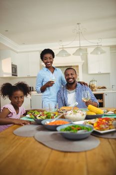 Portrait of happy family having meal on dinning table at home
