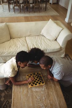 Family playing chess together at home in the living room at home