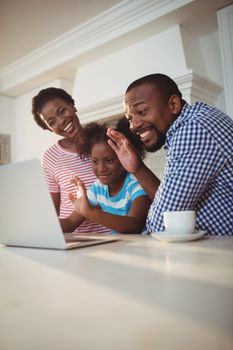 Happy family having a video call on laptop at home