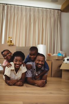 Portrait of happy family lying on top of each other on the bed in bedroom