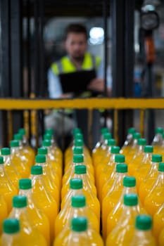 Close-up of juice bottles arranged in rows at factory