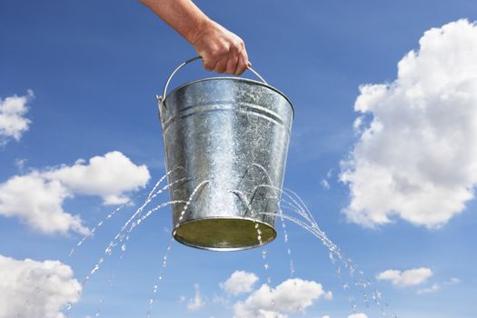 Man holding bucket with holes leaking water themes of emergency concept losing metaphor