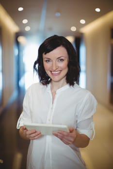 Portrait of female business executive holding digital tablet in office