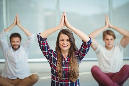 Business executives practicing yoga in office