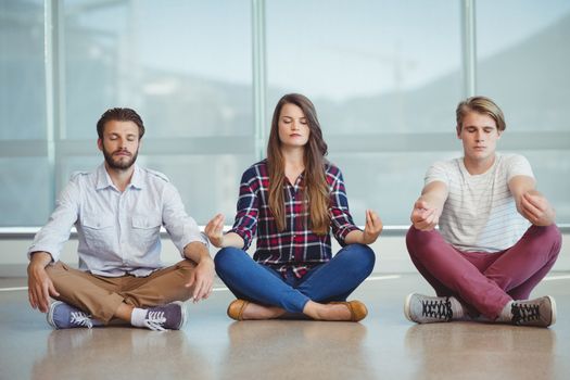 Business executives practicing yoga in office