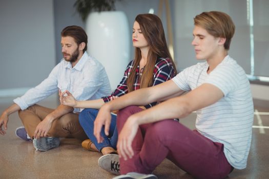 Business executives practicing yoga in office