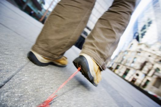 Low view of a man with bubble gum stuck to his shoe themes of accident problems unhygenic