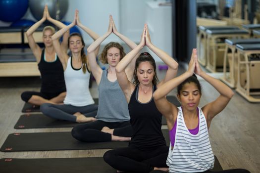 Group of women performing yoga in gym