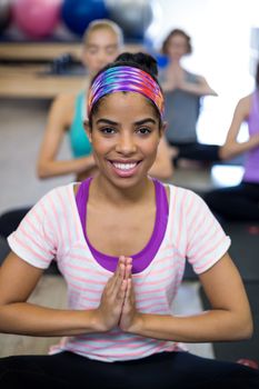 Portrait of smiling woman doing yoga in gym
