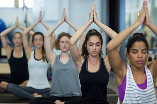 Group of women performing yoga in gym