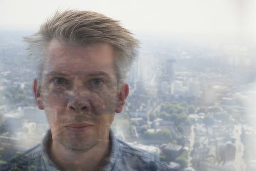 Elevated view reflection of a caucasian businessman looking out of an office window