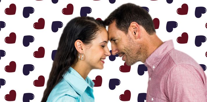 Smiling couple touching foreheads against background with hearts