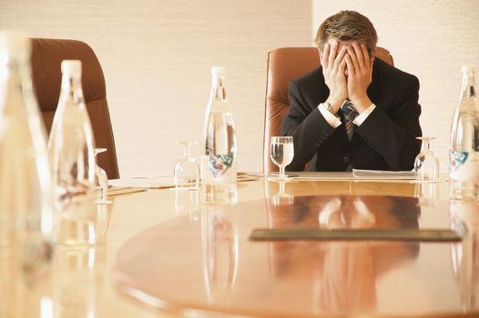 Depressed caucasian businessman in a hotel boardroom themes of despair frustration