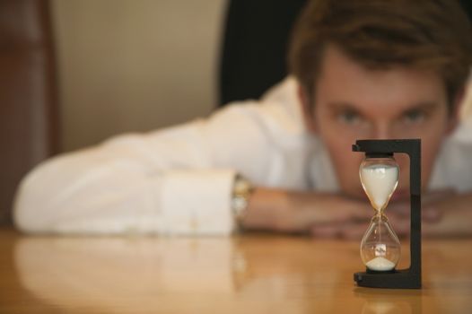 Middle aged caucasian businessman watching an sand timer