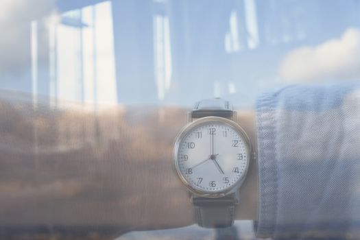 Reflection personal perspective of a caucasian businessman looking at his wristwatch in the office