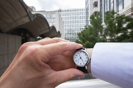 Personal perspective of a caucasian businessman looking at his wristwatch themes of deadlines departure late