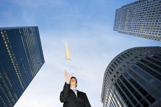 Low angle view of a caucasian businessman throwing a paper airplane
