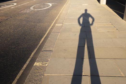 Personal perspective shadow of a man putting hands on his hips at sunset leaving the office