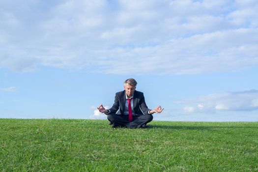 Businessman practicing yoga in the lotus position themes of wellness yoga escapism