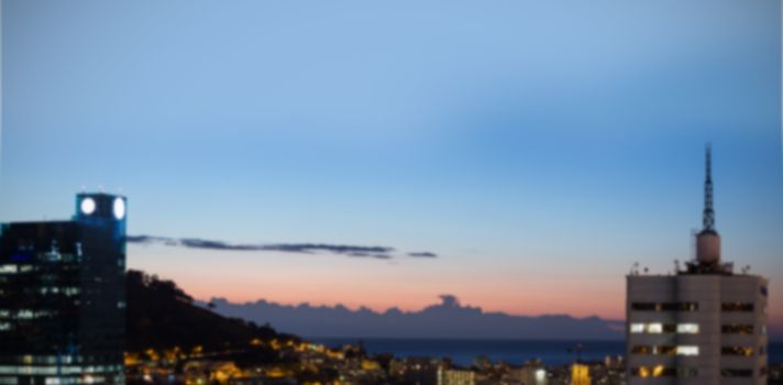 Illuminated buildings in city against sky at dusk