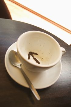 Tea leaves in a tea cup in the shape of an arrow themes of future direction decision