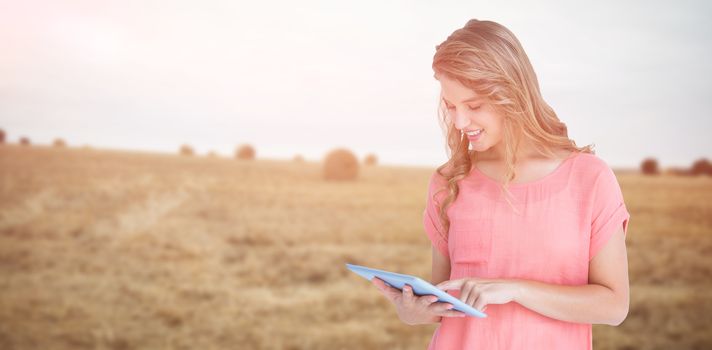 Hipster woman holding tablet pc  against view of harvested field