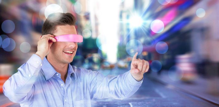 Smiling young man gesturing while using virtual reality headset against blurry new york street