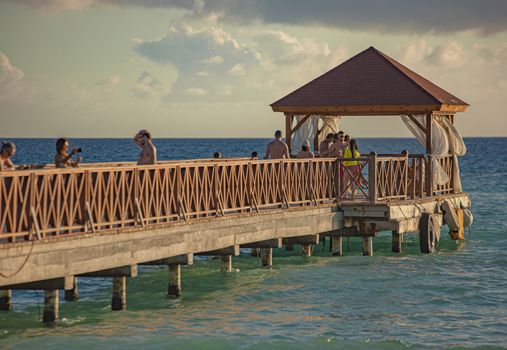 DOMINICUS, DOMINICAN REPUBLIC 6 FEBRAURY 2020: People walk on the Dominicus pier at sunset