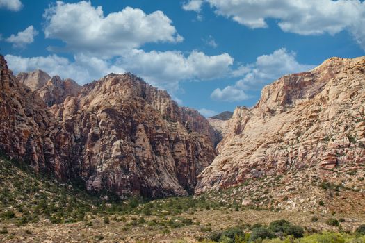 Brown mountains rising out of the desert into blue skies