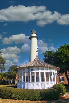 A white gazebo and lighthouse under a clear blue sky