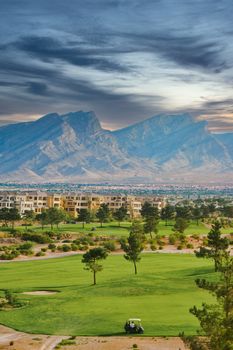 Desert golf course and condominiums by a mountain range