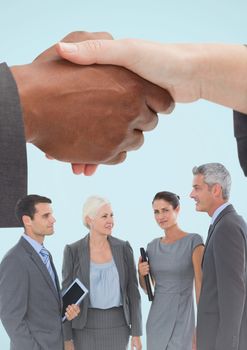 Digital composite of Handshake with business people and blue background
