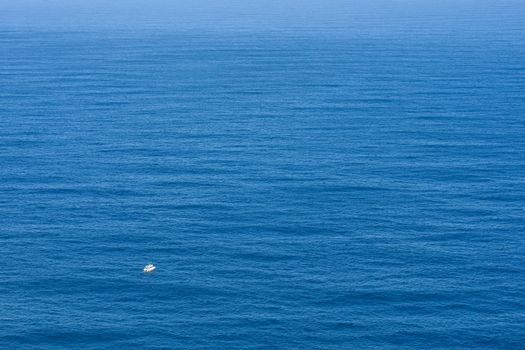 A small powerboat facing the endless vastness of open ocean, Cape Town, South Africa