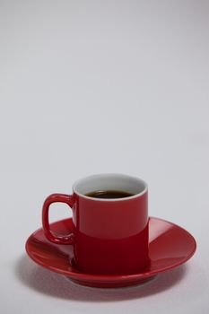 Black coffee served in red cup on white background