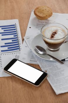 Coffee cup with document and mobile phone on wooden background