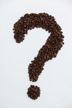 Coffee beans forming question mark on white background