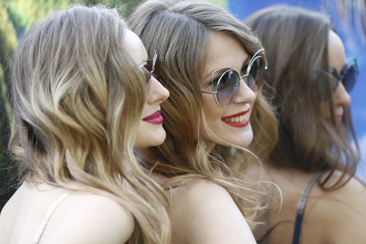 The faces of three models.Women in sunglasses