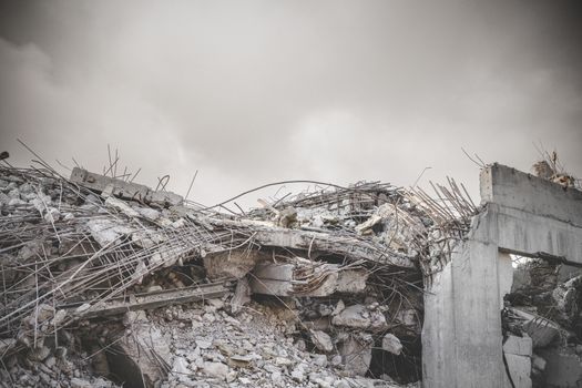 Ruin in a war zone with a damaged concrete building under a cloudy sky