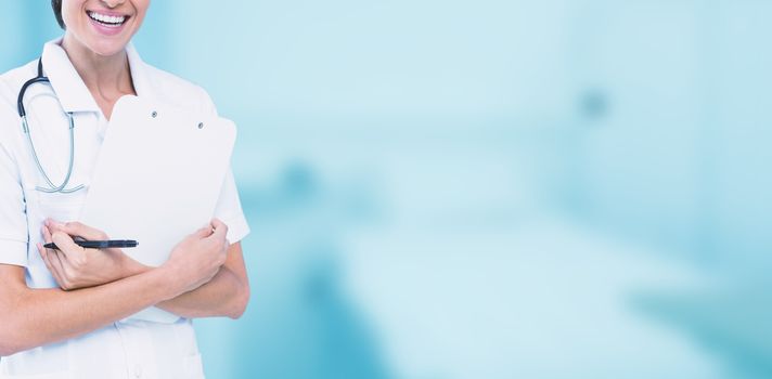 Portrait of cheerful female doctor holding clipboard against dental equipment