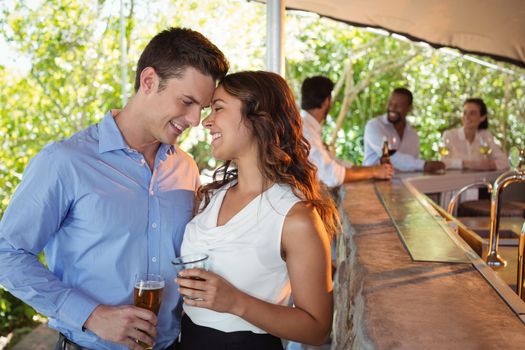 Romantic couple having a glass of beer at counter in restaurant