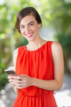 Portrait of beautiful woman smiling while using mobile phone