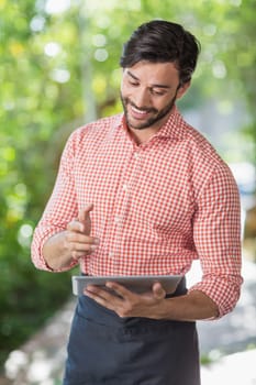 Male waiter using digital tablet in the restaurant